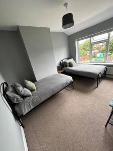 a bedroom with two beds and a window at Fabulous 3bed off street parking in Stafford