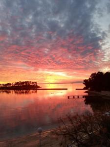 a sunset over a body of water with the sun setting at Apartman Hana 2 in Rab +4 photos