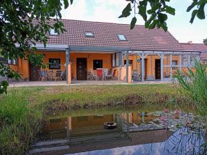 una casa con un estanque delante de ella en Ferienwohnungen 20er en Byhleguhre-Byhlen