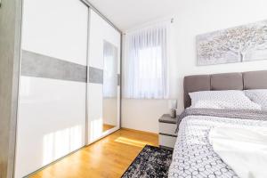 a bedroom with a bed and a large mirror at Apartman Lux in Virovitica