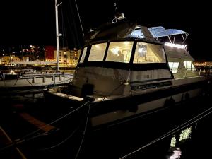 Navï, yacht privé face au Mont Saint-Clair في سيت: يتم رسو قارب في الميناء في الليل