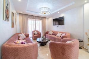 een woonkamer met 2 banken en een tafel bij Résidence Coralia les orangers in Marrakesh