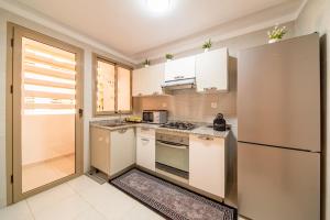 een keuken met witte kasten en een koelkast bij Résidence Coralia les orangers in Marrakesh