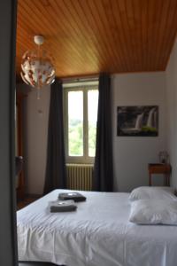 ein Schlafzimmer mit einem weißen Bett und einem Fenster in der Unterkunft Hôtel Restaurant des Lacs in Chaux-des-Crotenay