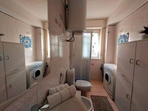 a bathroom with a toilet and a washing machine at Terrazza sul mare - a pochi minuti da Taormina in Giardini Naxos