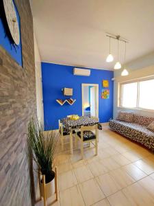 a living room with a table and a blue wall at Terrazza sul mare - a pochi minuti da Taormina in Giardini Naxos