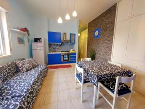 Habitación con mesa, sofá y cocina. en Terrazza sul mare - a pochi minuti da Taormina, en Giardini Naxos