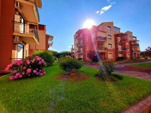 a building with the sun shining on a yard with flowers at Terrazza sul mare - a pochi minuti da Taormina in Giardini Naxos