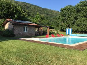 a swimming pool with chairs next to a house at MyVilla Suites in Palazzo Canavese