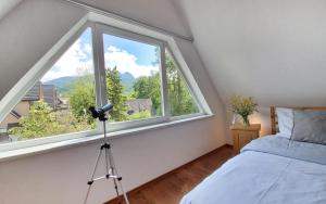 a bedroom with a large window and a camera at Ozwa SKY in Zakopane