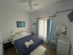 a bedroom with a bed with two towels on it at Yannis Maria Rooms in Antiparos