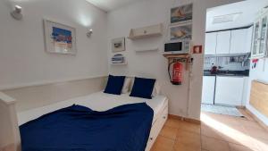アルブフェイラにあるSailing Studio Açoteiasのベッドルーム1室(青いシーツ付きのベッド1台、キッチン付)