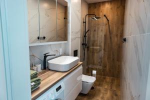 a bathroom with a sink and a shower at Apartament 2 Komfort in Słupsk