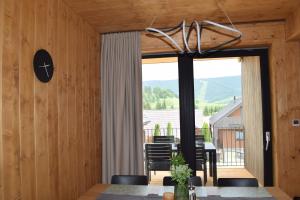 a dining room with a table and a large window at Luxury Chalet Telgart in Telgárt