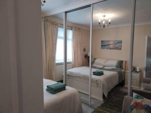 a bedroom with two beds and a mirror at Wembley 2 Bed/2 Bath Modern Apt in London