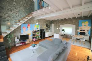 a living room with a gray couch and a staircase at Villas San Roque Isla in Isla