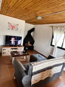 een woonkamer met een bank en een tv bij Ave Fénix in Aguas Dulces