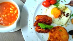a plate of breakfast food with an egg and bacon at HOTEL de la POSTE in Esch-sur-Alzette