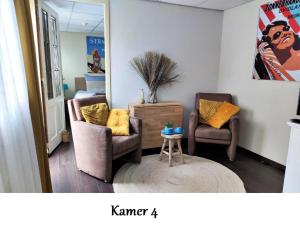ein Wohnzimmer mit 2 Stühlen und einem Tisch in der Unterkunft Zeelui in Egmond aan Zee