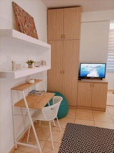 een woonkamer met een bureau en een televisie bij Thess Vibes @ City Center in Thessaloniki