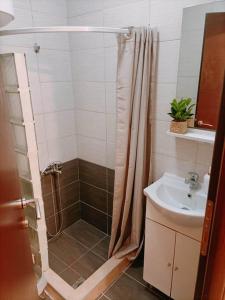 een badkamer met een douche en een wastafel bij Thess Vibes @ City Center in Thessaloniki