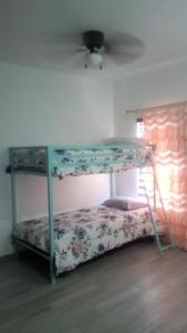 Dormitorio con litera y sábanas de flores en Monte Mar 7A en Divisadero