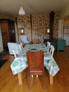 a dining room table with chairs and a living room at Le Relais d'Anglards in Anglards-de-Saint-Flour