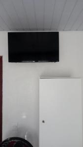 a flat screen tv hanging on a white wall at Hotel Copacabana in Araucária