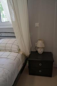 a bedroom with a bed and a lamp on a dresser at Zak's House in Platamonas