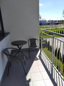 a patio with two chairs and a table on a balcony at Apartament Długa Uniejów in Uniejow