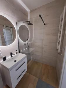 a white bathroom with a sink and a mirror at Apartament Długa Uniejów in Uniejow