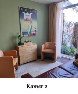 ein Wohnzimmer mit einem Stuhl und einer Kommode in der Unterkunft Zeelui in Egmond aan Zee