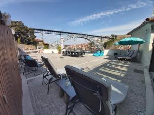 a group of chairs and an umbrella on a patio at Bridge It - Suites & Views in Vila Nova de Gaia