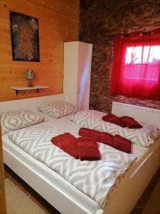 Un dormitorio con una cama con toallas rojas. en Apartma Suzy en Pobegi