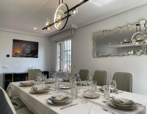 Moderna Casa de Lujo con Jardín y Barbacoa في مدريد: غرفة طعام مع طاولة وكراسي طويلة