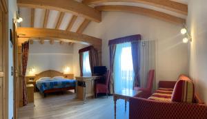 una camera con letto e divano di Hotel Laurin a Canazei