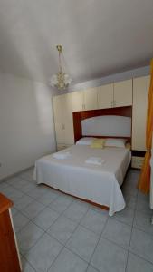 a bedroom with a large white bed in a room at Apartmani Galiot in Kaštela