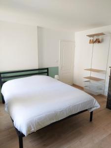 a white bed in a room with a shelf at ° Appart 3 - Lunéville centre ° in Lunéville