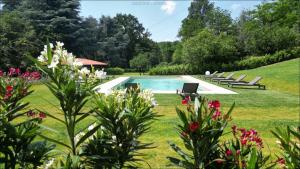ein Swimmingpool in einem Hof mit Stühlen und Blumen in der Unterkunft Cascina Ravona in San Fermo della Battaglia