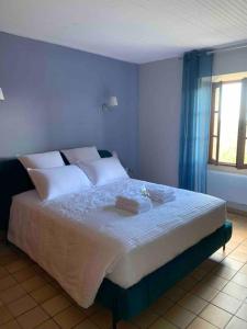 um quarto com uma cama com lençóis brancos e uma janela em U Granu di Bellezza em Casta