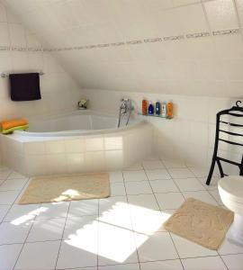 a white bathroom with a tub and a toilet at Ferienwohnung nahe der Ostsee in Steinhagen