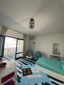 1 dormitorio con 1 cama y 1 dormitorio con mesa en Charmant Studio vue mer @Kantaoui - 1min à pied de la plage en Hammam Sousse