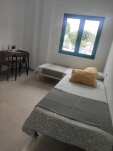 a room with two beds and a table with a window at Crismela in Yaiza