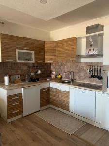 a kitchen with wooden cabinets and white appliances at Guesthouse HHL - Liman ll in Ulcinj