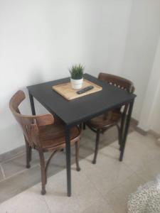 a black table with two chairs and a plant on it at Crismela in Yaiza