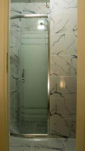 um chuveiro com uma porta de vidro na casa de banho em BELİS APART & PANSİYON em Kemer