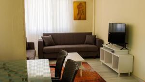 a living room with a couch and a tv at BELİS APART & PANSİYON in Kemer