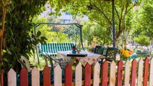 a white picket fence with a table in a yard at BELİS APART & PANSİYON in Kemer
