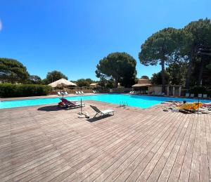 een zwembad met ligstoelen en een zwembad bij Cala Rossa by Saraï, Apt T2 4 personnes, dans Résidence hôtelière avec piscine in Lecci