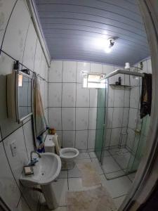 a bathroom with a shower and a toilet and a sink at Pequizeiro Eco Pousada in Cavalcante